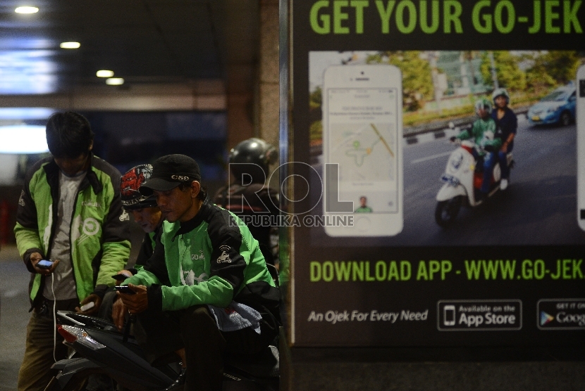  Pengemudi ojek online menunggu penumpang di Kawasan Sudirman, Jakarta Selatan, Jumat (18/12).