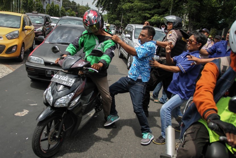 Pengemudi taksi terlibat ricuh dengan pengemudi gojek yang melintas saat unjuk rasa menolak operasi Go-jek di Balaikota Solo, Jawa Tengah, Rabu (15/3).