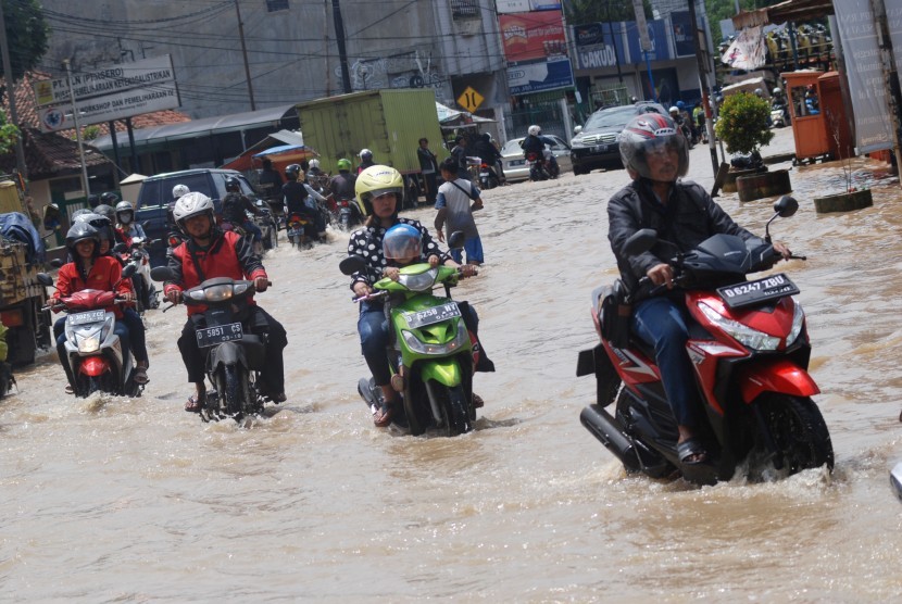 Pengendara berusaha melintasi kawasan banjir di Dayeuhkolot, Kabupaten Bandung, Jawa Barat, Senin (14/11). 