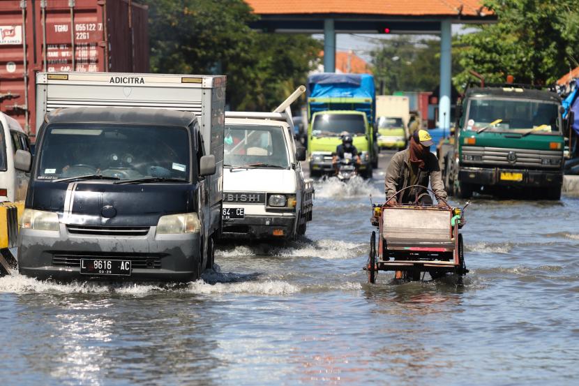 Pengendara kendaraan bermotor menerjang banjir rob di Jalan Kalimas Baru, Surabaya, Jawa Timur, Sabtu (29/5/2021). Pasang air laut yang tinggi menyebabkan sebagian akses jalan menuju Pelabuhan Kalimas dan penyeberangan Ujung (Surabaya)-Kamal (Madura) tersebut terendam banjir rob.