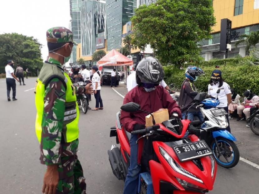Pengendara kendaraan bermotor menjalani pemeriksaan ketat di pintu masuk Kota Surabaya, tepatnya di perbatasan Sidoarjo-Surabaya, Selasa (28/4). Pemeriksaan dilakukan setelah diterapkannya Pembatasan Sosial Berskala Besar (PSBB) dalam upaya menekan penularan Covid-19.