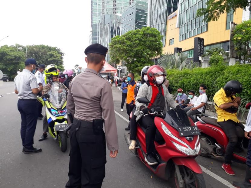 Pengendara kendaraan bermotor menjalani pemeriksaan ketat di pintu masuk Kota Surabaya, tepatnya di perbatasan Sidoarjo-Surabaya, Selasa (28/4). Pemeriksaan dilakukan setelah diterapkannya Pembatasan Sosial Berskala Besar (PSBB) dalam upaya menekan penularan Covid-19