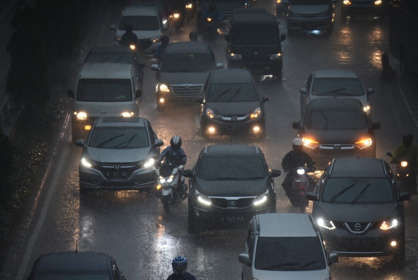 Pengendara meliintasi hujan di kawasan Gatot Subroto, Jakarta, Senin (11/2/2019).