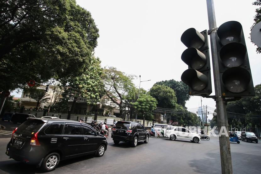 Pengendara melintas di dekat lampu lalu lintas yang tidak berfungsi di Jalan Diponegoro, Jakarta, Senin (5/8/2019).