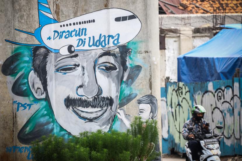 Pengendara melintas di dekat mural tentang aktivis HAM Munir Said Thalib di Jakarta