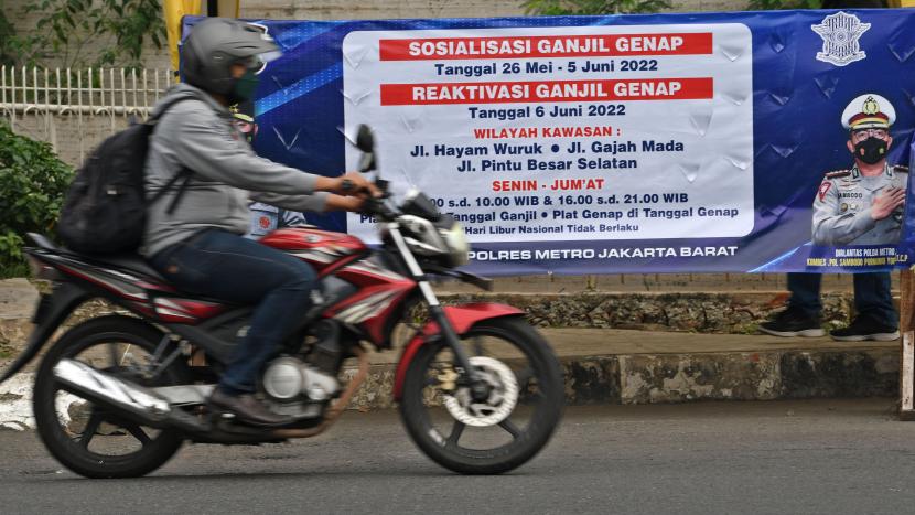 Pengendara melintas di dekat spanduk sosialisasi pemberlakuan aturan ganjil genap di Jalan Gajah Mada, Jakarta, Senin (6/6/2022). Ganjil Genap di DKI Jakarta Berlaku Mulai Hari Ini