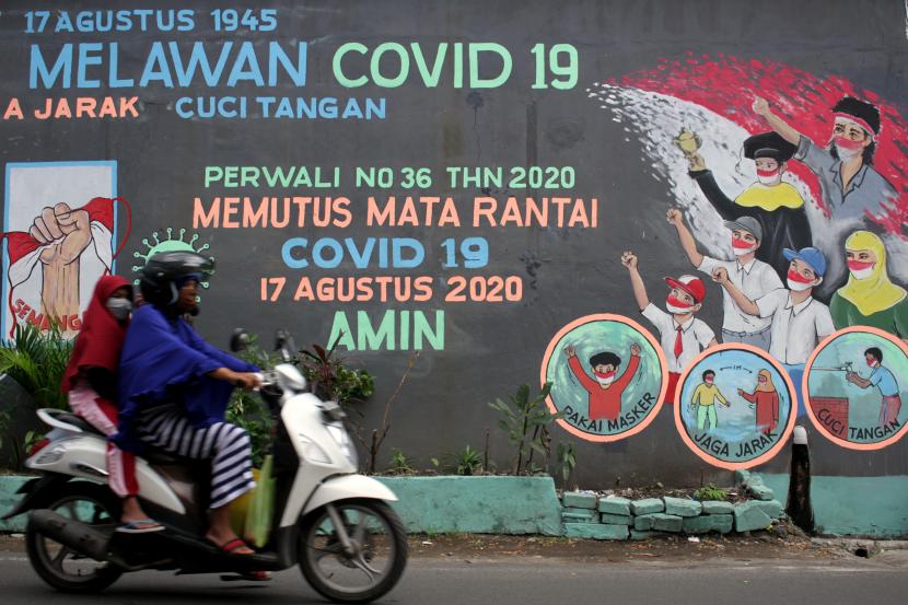 Pengendara melintas di depan mural bertema Semangat Kemerdekaan Melawan COVID-19 di Makassar, Sulawesi Selatan, Kamis (13/8/2020). Mural tersebut dibuat untuk meningkatkan semangat warga di daerah itu dalam memutus rantai penularan COVID-19 dengan tetap menerapkan protokol kesehatan saat peringatan HUT ke-75 Kemerdekaan Republik Indonesia.