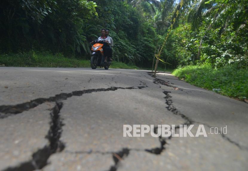 Pengendara melintas di jalan yang rusak akibat gempa di Pasaman Barat (ilustrasi)