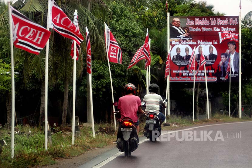 Pengendara melintas di samping jejeran bendera Partai Aceh (PA) di kawasan Kandang Lhokseumawe, Provinsi Aceh, Kamis (20/10). Partai Aceh yang mayoritas dimotori mantan Gerakan Aceh Merdeka (GAM) merupakan partai pemenang Pilkada Aceh 2012 dengan perolehan