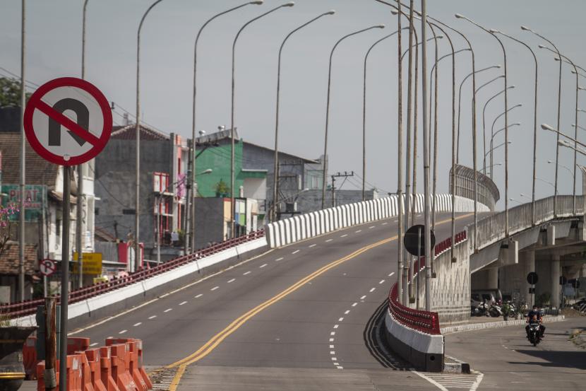 Pengendara melintas di samping jembatan Flyover Palur yang ditutup di Karanganyar, Jawa Tengah, Rabu (14/7/2021). Polres Karanganyar menutup total jalan layang atau flyover yang menghubungkan Kota Solo dengan Kabupaten Karanganyar tersebut untuk mengurangi mobilitas warga selama Pemberlakukan Pembatasan Kegiatan Masyarakat (PPKM) Darurat. 