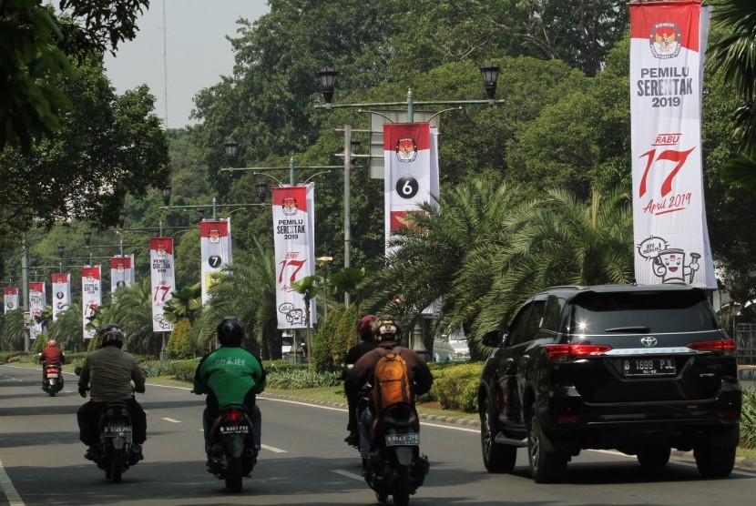 Pengendara melintas di samping spanduk sosialisasi Pemilu Serentak 2019 KPU di kawasan Jalan Imam Bonjol, Jakarta, Sabtu (7/7). 