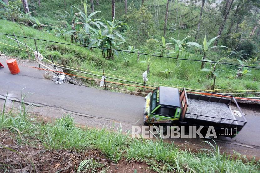 Pengendara melintas di sisi jalan sirip Tulungagung-Trenggalek yang ambrol terseret longsor.