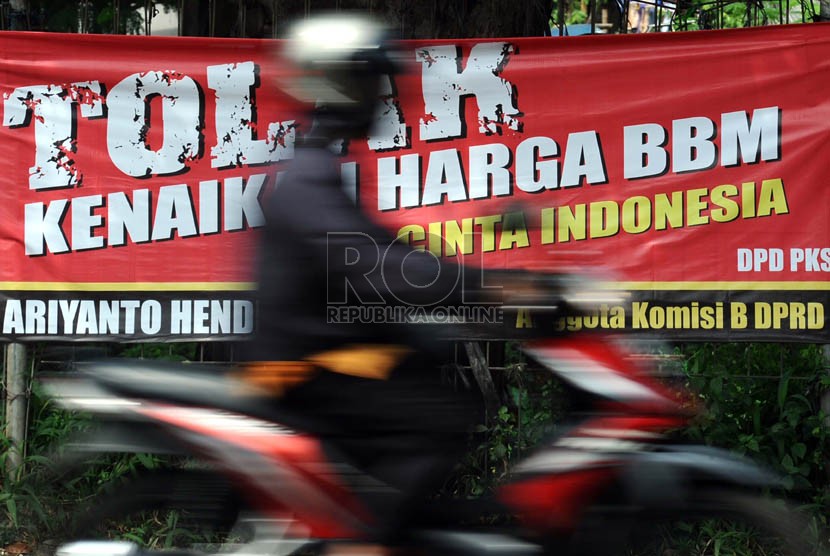  Pengendara melintas didepan spanduk penolakan kenaikan BBM di Jakarta, Jumat (7/6).  (Republika/Tahta Aidilla)