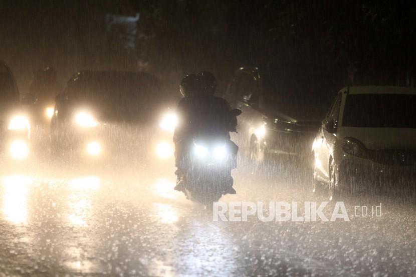 Pengendara melintas jalan yang diguyur hujan lebat (ilustrasi).