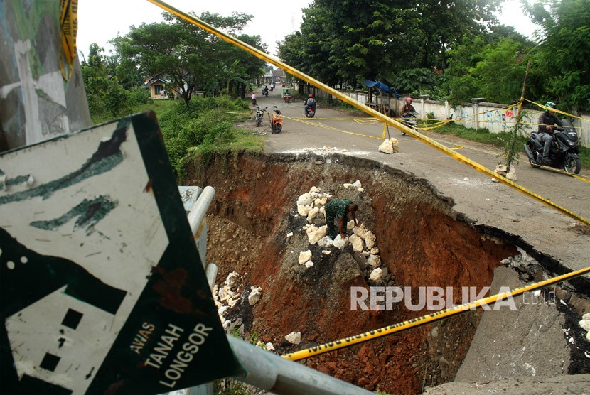 Pengendara melintas tak jauh dari jalan yang amblas di Kabupaten Bekasi, Jawa Barat