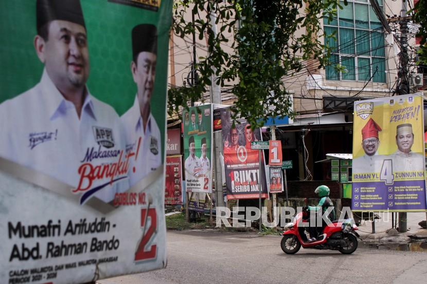 Pengendara melintasi alat peraga kampanye (APK) di Jalan Hertasning, Makassar, Sulawesi Selatan, Senin (7/12/2020). Memasuki hari kedua masa tenang pilkada serentak 2020, beberapa APK pasangan calon Wali Kota dan Wakil Wali Kota Makassar di sejumlah titik belum ditertibkan. 