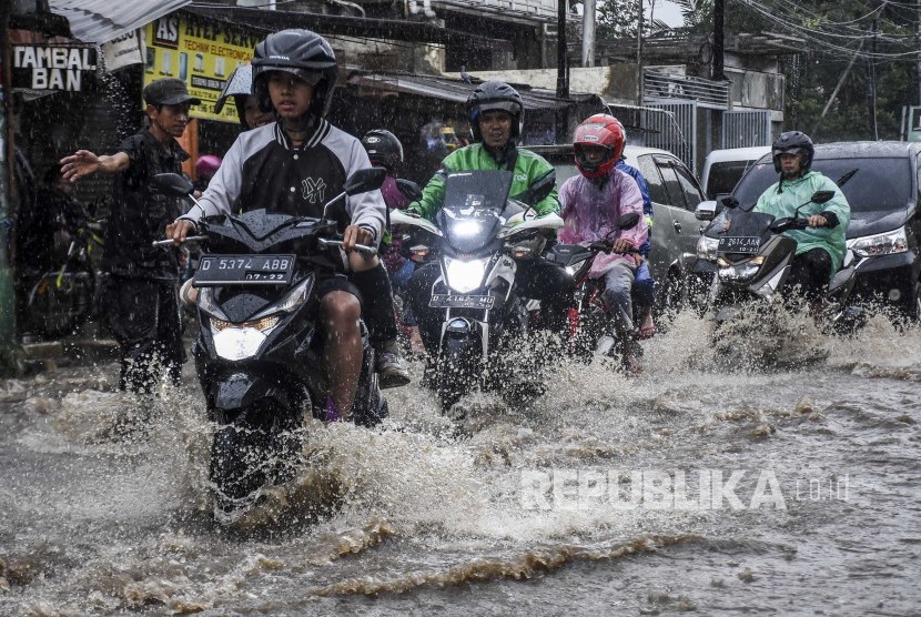 Pengendara melintasi derasnya arus air saat banjir di kawasan Cikutra, Kota Bandung. 