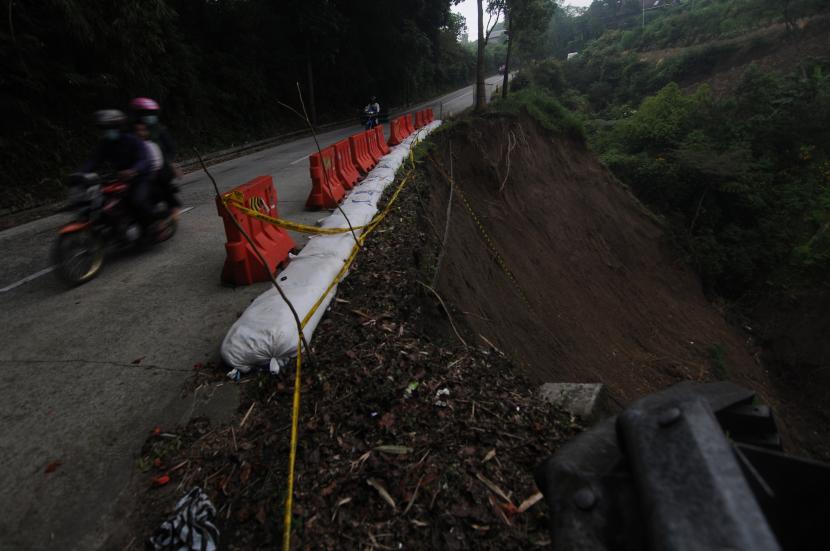 Pengendara melintasi jalan yang longsor sebagian di Boyolali, Jawa Tengah. Jalur tersebut rawan longsor jika saat hujan, sehingga pengendara diharapkan untuk waspada (ilustrasi). 