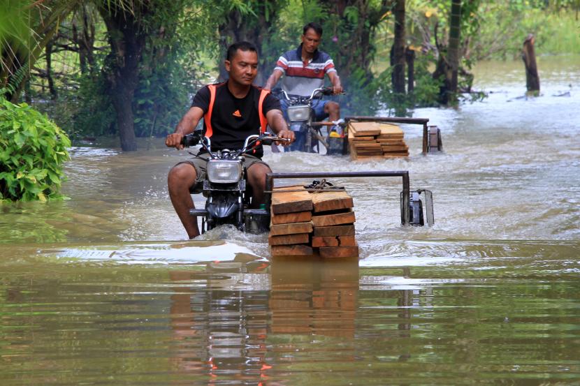 Pengendara melintasi jalan yang terendam banjir di Desa Pasi Leuhan, Kecamatan Johan Pahlawan, Aceh Barat, Aceh, Sabtu (2/5/2020). Banjir yang disebabkan tingginya intensitas hujan sejak dua hari terakhir mengakibatkan puluhan rumah warga di Kecamatan Johan Pahlawan, Samatiga, Bubon, Kawa