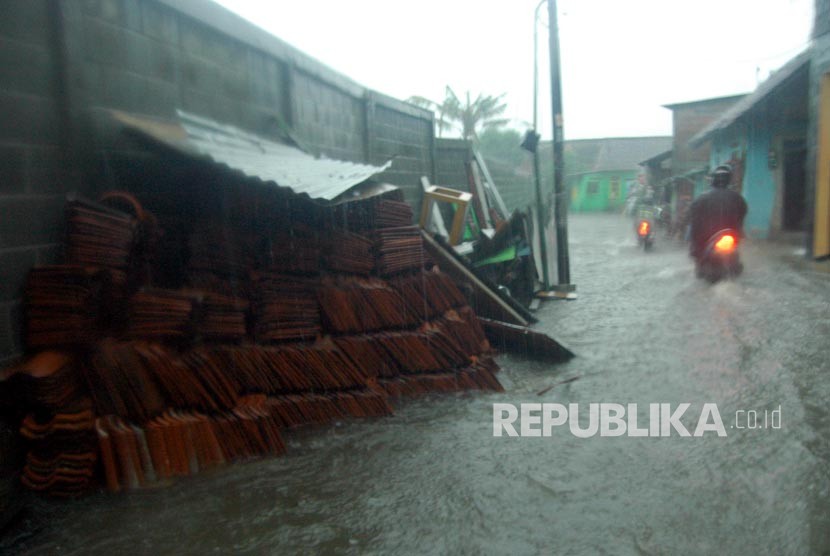 Pengendara melintasi jalan yang tergenang air di gang Mangga Janti, desa Catur Tunggal, Kecamatan Depok, Kabupaten Sleman, Yogyakata, Selasa (28/11). 