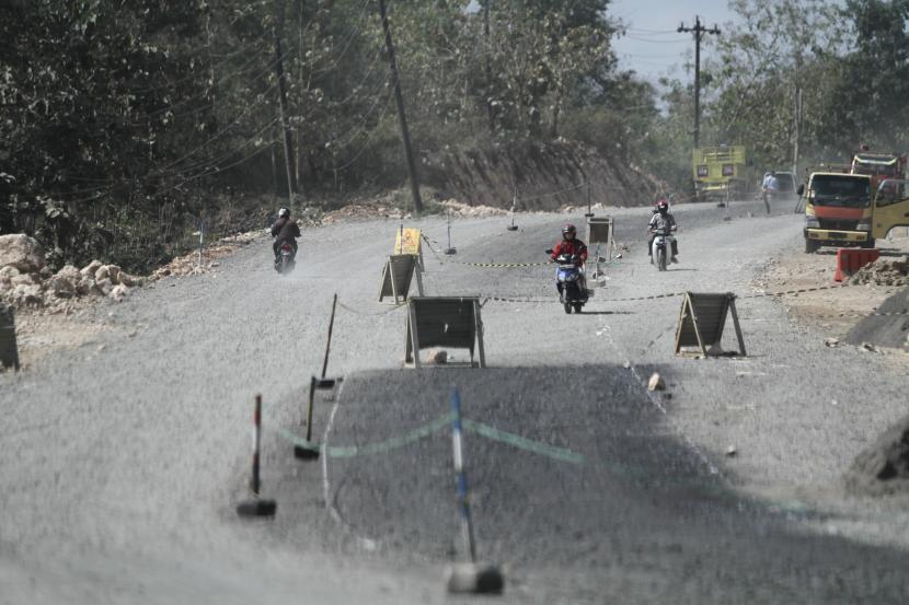 Pengendara melintasi proyek pembangunan Jalur Jalan Lintas Selatan (JJLS) di Gunungkidul, DI Yogyakarta.