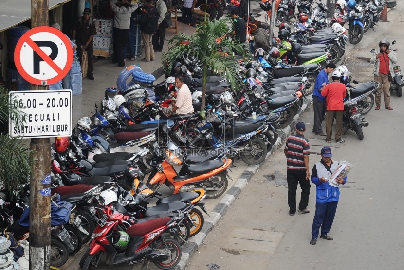  Pengendara memarkirkan kendaraannya di Trotoar Jalan Gajah Mada, Jakarta Barat, Rabu (1/4). 