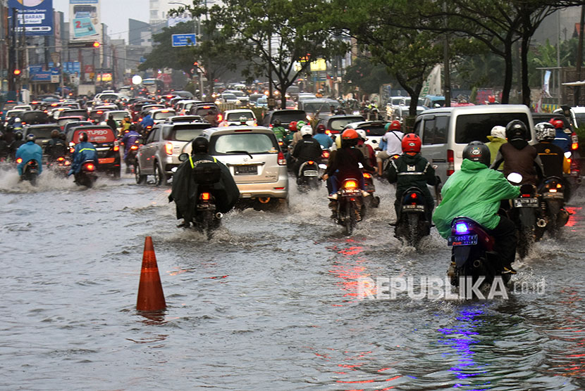 Pengendara memperlambat laju kendaraannya saat melintasi genangan banjir di kawasan Margonda, Depok, (ilustrasi).