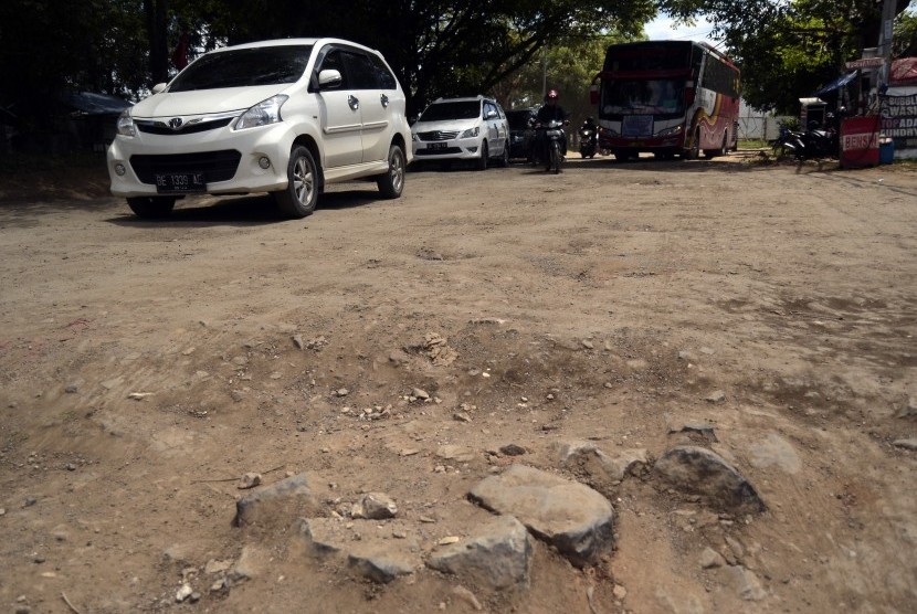 Pengendara memperlambat laju kendaraannya saat melintasi jalan rusak, di Jalan Ryacudu Sukarame, Bandar Lampung, Lampung, Sabtu (30/3/2019).