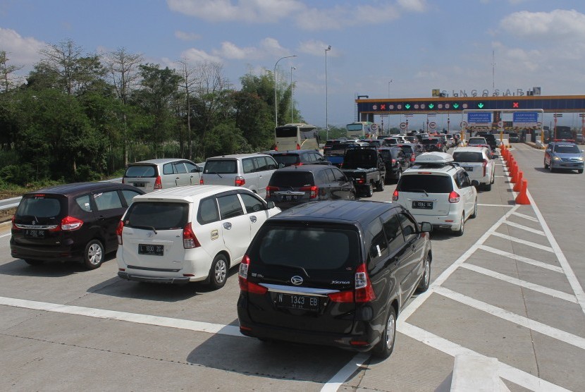 Pengendara mobil antre saat melewati gerbang jalan tol Malang-Pandaan, Singosari, Malang, Jawa Timur, Sabtu (1/6/2019). 