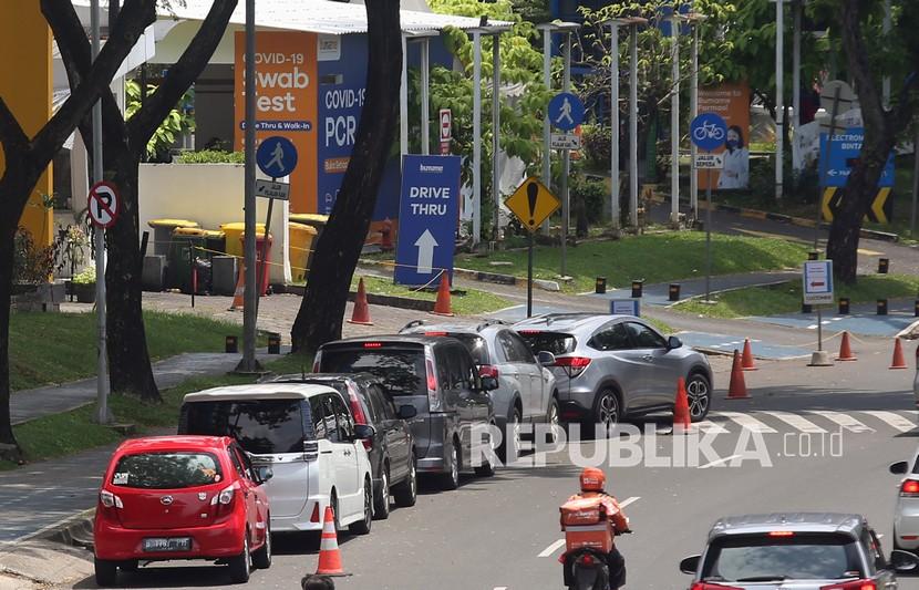 Pengendara mobil antre untuk melakukan tes usap PCR dan Antigen COVID-19 secara Drive Thru di Bintaro, Tangerang Selatan, Banten, Kamis (3/2/2022). Panjang antrean mobil yang hendak melakukan tes usap COVID-19 ini mencapai 300 meter hingga 500 meter ke belakang.