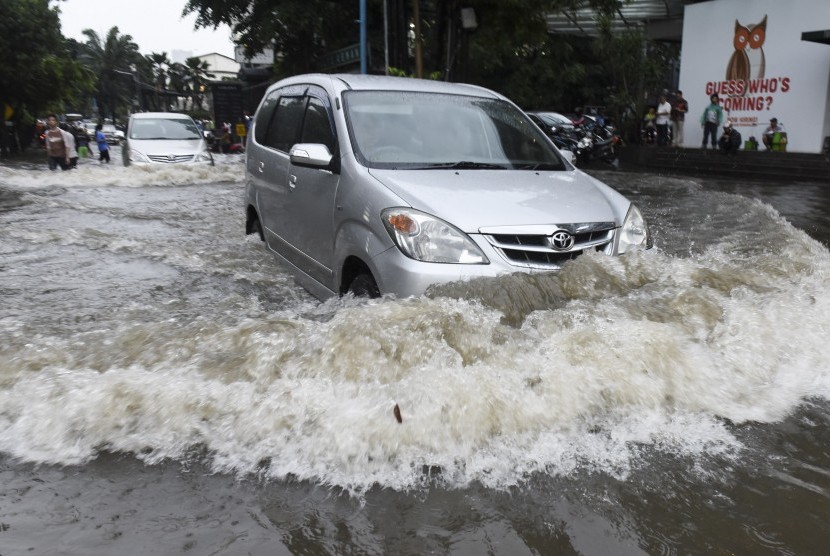 Pengendara mobil berusaha menerobos banjir di kawasan Kemang, Jakarta, Jumat (11/11). 