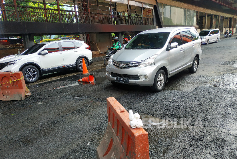 Pengendara mobil bermanuver menghindari badan jalan rusak di Jl HR Rasuna Said Jakarta, Rabu (4/1/2023). 