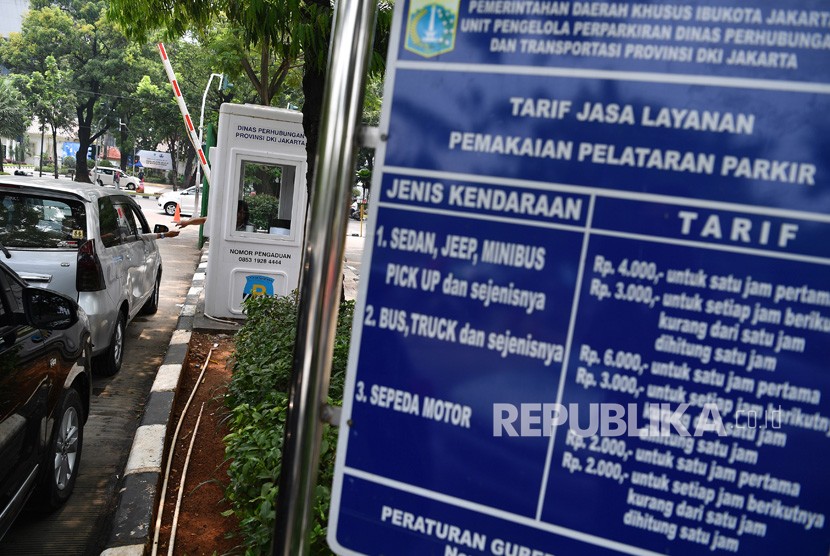 Pengendara mobil membayar parkir di lapangan IRTI Monas, Jakarta Pusat.