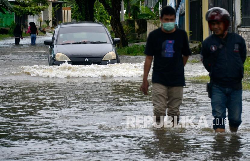 Pengendara mobil menerobos banjir yang menggenangi ruas jalan di Perumahan Antang, Kecamatan Manggala, Makassar, Sulawesi Selatan