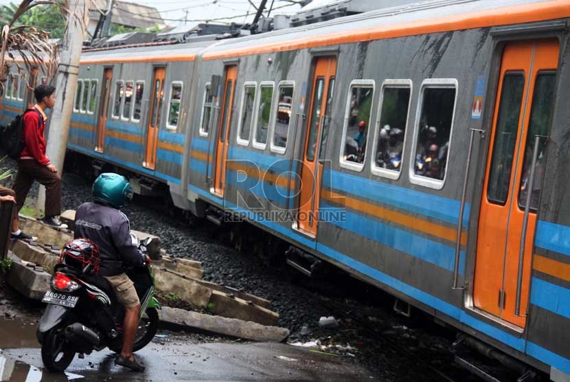   Pengendara motor berhenti di perlintasan kereta api di Pesanggrahan, Bintaro, Jakarta, Rabu (11/12).     (Republika/Yasin Habibi)