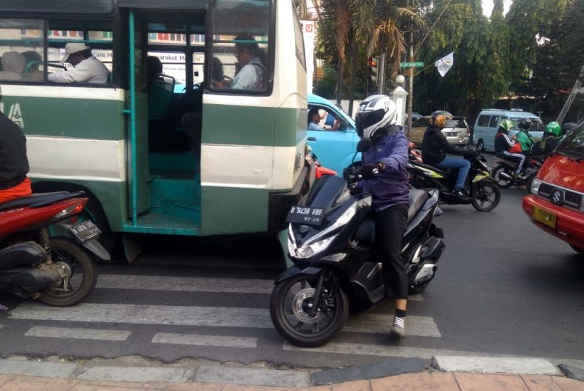 Pengendara motor dan mobil terlihat berhenti di zebra cross lampu merah jalan Ragunan Raya.  Bahkan, ada beberapa pengendara berhenti di luar batas penyeberangan, Jakarta, Kamis (1/8). 
