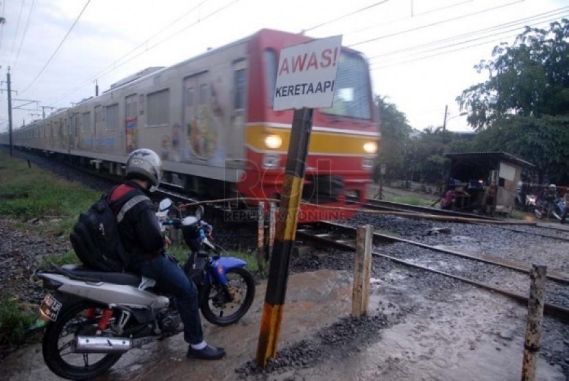  Pengendara motor di perlintasan kereta api tanpa palang pintu. (ilustrasi)