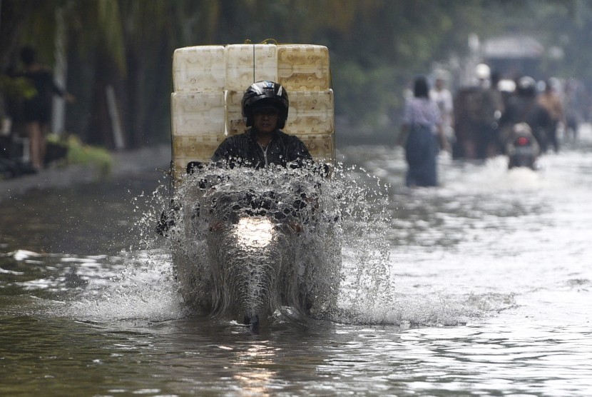Pengendara motor melewati banjir yang melanda Jalan Gaya Motor, Sunter, Jakarta Utara, Kamis (25/2).