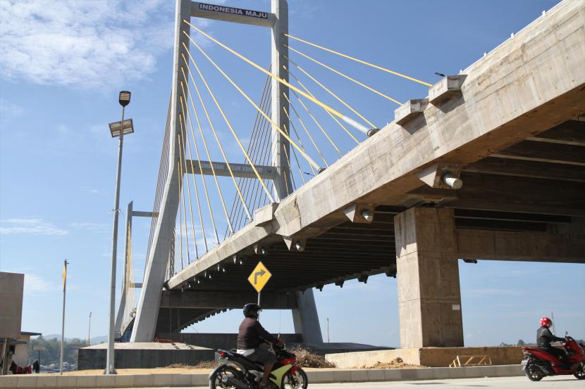 Pengendara motor melintas di bawah Jembatan Teluk Kendari yang telah tuntas pembangunannya di Kendari, Sulawesi Tenggara, Rabu (21/10). Presiden Joko Widodo meresmikan Jembatan Teluk Kendari sepanjang 1,34 Kilometer pada Kamis (22/10).
