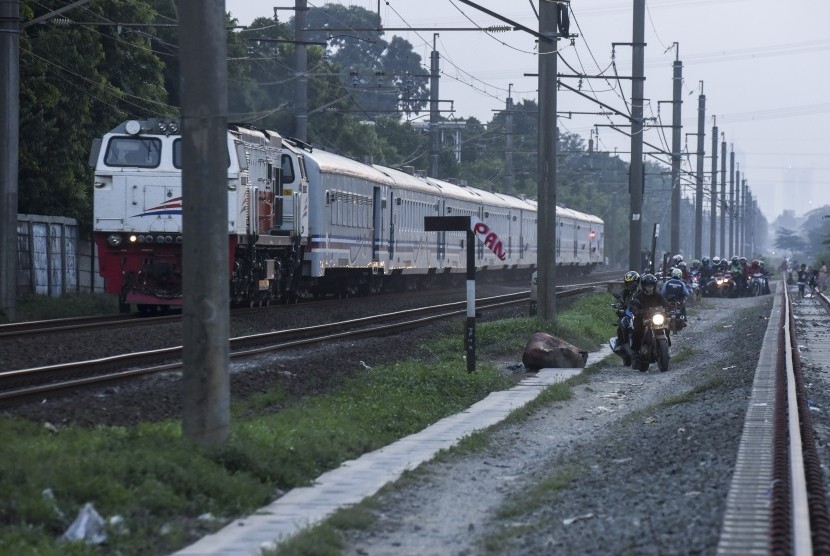 Pengendara motor melintas di dekat rel kereta api di Kawasan Buaran, Jakarta. 