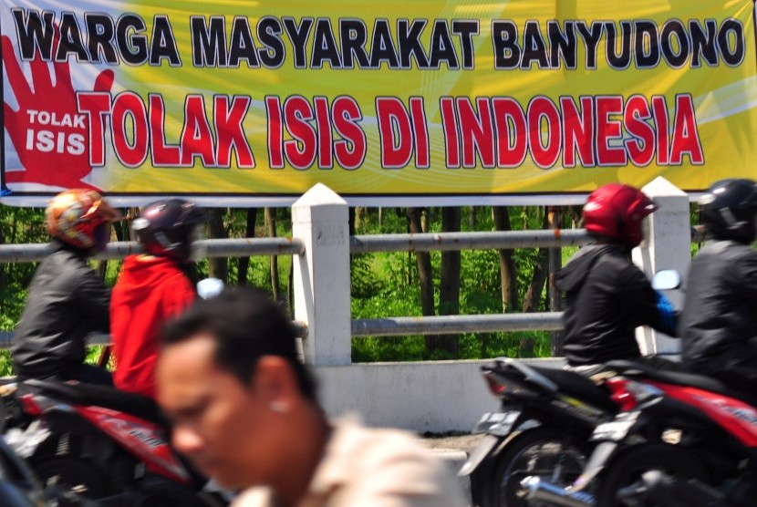 Pengendara motor melintas di dekat spanduk himbauan menolak ISIS yang terpasang di pinggir jalan Solo-Boyolali, Jawa Tengah, Kamis (2/4).