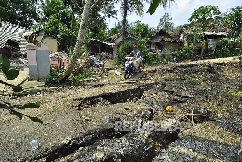 Pengendara motor melintas di jalan yang rusak akibat pergerakan tanah di Kampung Cikatomas, Sasak Gantung, Desa Citatah, Kecamatan Cipatat, Kabupaten Bandung Barat, Rabu (23/11). 