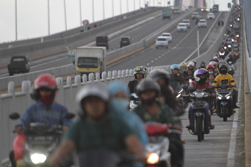 Pengendara motor melintas di Jembatan Suramadu, Surabaya, Jawa Timur, Sabtu (30/4/2022). Volume lalu lintas kendaraan mudik menuju Jawa Timur terpantau tinggi.