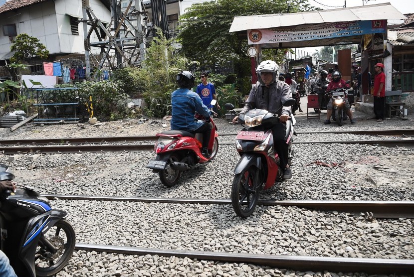 Pengendara motor melintas di perlintasan kereta api tanpa palang pintu di kawasan Petamburan, Jakarta, Selasa (2/7/2019). 