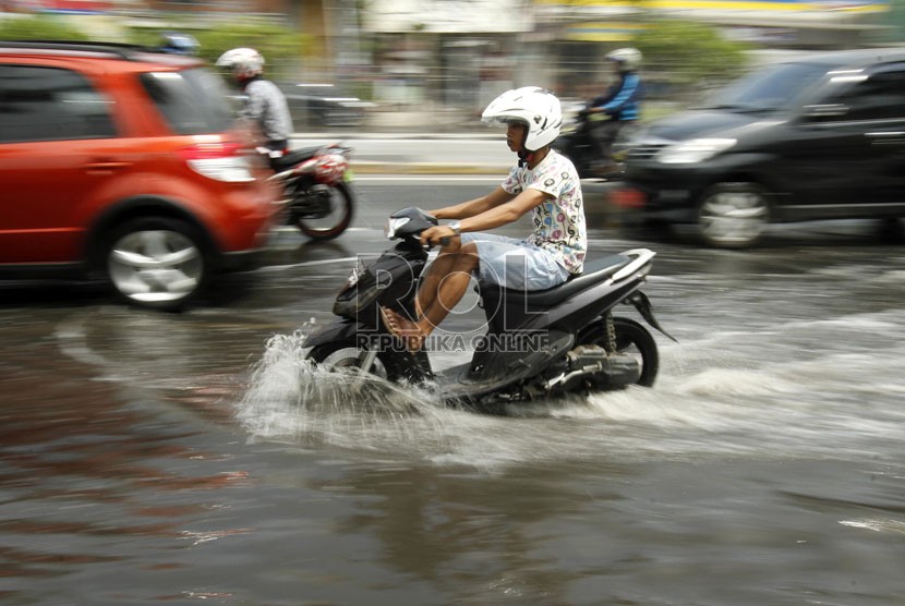  Pengendara motor melintasi jalan yang tergenang air di kawasan Gunung Sahari, Mangga Dua, Jakarta Utara, Jumat (14/12).   (Republika/Adhi Wicaksono)