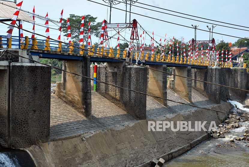 Pengendara motor melintasi sungai Ciliwung di jembatan Bendung Katulampa, Kota Bogor, Jawa Barat, Kamis (15/8/2019). Hingga pukul 10.00 WIB, tinggi muka air (TMA) di Bendung Katulampa Kota Bogor, yang mengalir ke Sungai Ciliwung terpantau berada di posisi terpantau Siaga IV.