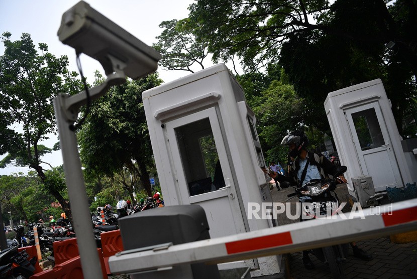 Pengendara motor membayar parkir di lapangan IRTI Monas, Jakarta Pusat, Jakarta, Senin (10/12/2018).