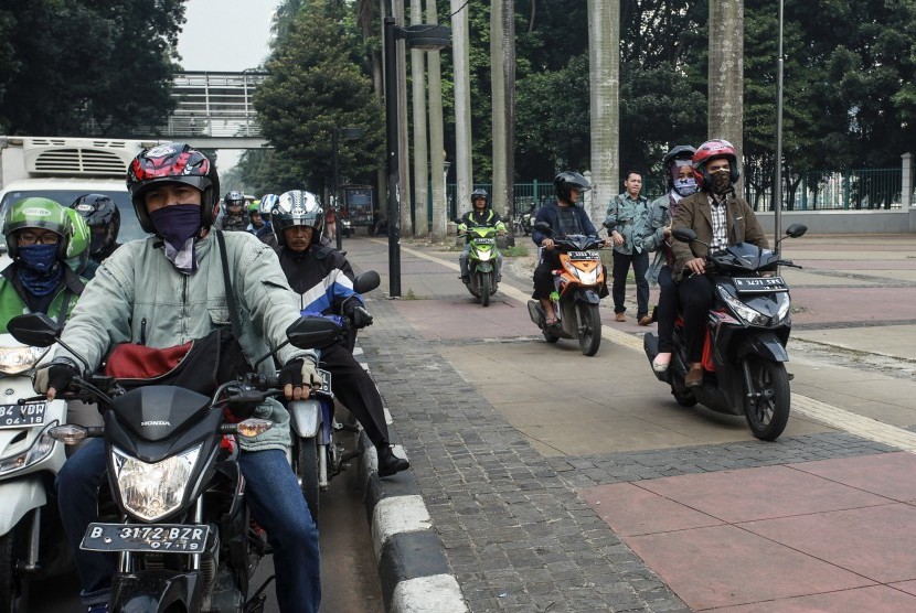 Pengendara motor mengendarai motornya diatas jalur pejalan kaki (trotoar) di kawasan jalan Jenderal Sudirman, Jakarta, Selasa (17/5). 