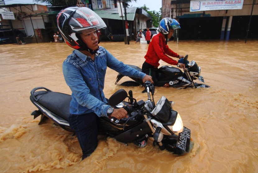 Pengendara motor nekat melewati banjir yang merendam Jalan Adinegoro, Padang, Sumatera Barat, Selasa (22/3).