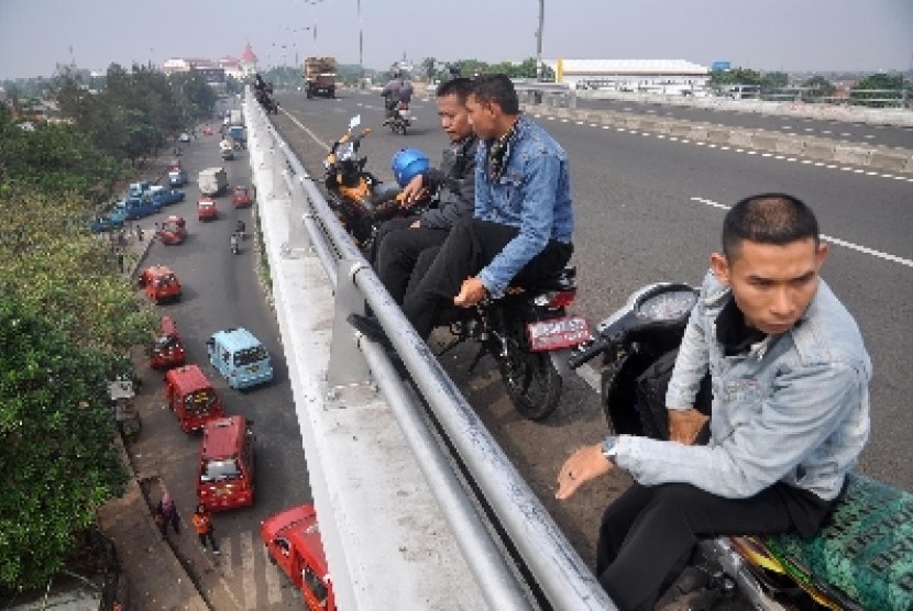 Pengendara motor tengah bersantai di sebuah flyover di Jakarta. 